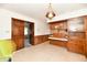 Retro kitchen features wood cabinets, white appliances, and wood paneled walls at 1500 S Anderson St, Elwood, IN 46036