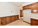 Retro kitchen with wood cabinets, a pass-through, and wood paneled walls at 1500 S Anderson St, Elwood, IN 46036