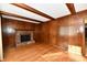 Spacious living room with hardwood floors, wood paneling, and a brick fireplace at 1500 S Anderson St, Elwood, IN 46036