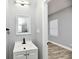 Small, updated bathroom with white vanity and mirror at 2318 E Brookside Ave, Indianapolis, IN 46218