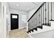 Modern entryway featuring a black front door and a sleek staircase at 2318 E Brookside Ave, Indianapolis, IN 46218