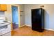 Black fridge in kitchen with wood cabinets and vinyl flooring at 3206 W 57Th St, Indianapolis, IN 46228