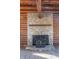 Stone fireplace with wood stove in a rustic log cabin setting at 4298 W 300 N, Anderson, IN 46011