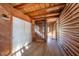 Hallway with log walls, exposed beams, and a staircase at 4298 W 300 N, Anderson, IN 46011