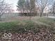 Large backyard with a grassy area and leaf covered ground at 581 Beehler Dr, Whiteland, IN 46184