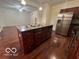 Kitchen island with stainless steel appliances and hardwood floors at 581 Beehler Dr, Whiteland, IN 46184