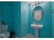 Small bathroom with teal walls and pedestal sink at 8231 Golden Ridge Ln, Indianapolis, IN 46237