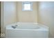Bathroom with a corner bathtub and a window at 8231 Golden Ridge Ln, Indianapolis, IN 46237