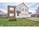 Two-story house with brick and beige siding, two-car garage, and landscaped yard at 8231 Golden Ridge Ln, Indianapolis, IN 46237