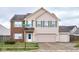 Two-story house with brick and beige siding, two-car garage, and landscaped yard at 8231 Golden Ridge Ln, Indianapolis, IN 46237