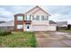 Two-story house with brick and beige siding, two-car garage, and landscaped yard at 8231 Golden Ridge Ln, Indianapolis, IN 46237