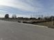 Empty lot with a gravel driveway, dirt piles, and construction fencing at 2974 S Kings Way, New Palestine, IN 46163