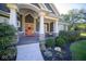 Inviting front porch with a coral door and well-maintained landscaping at 13829 N Gray Rd, Carmel, IN 46033