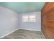 Bright bedroom with wood accent wall, new flooring, and double window at 1535 N Glen Arm Rd, Indianapolis, IN 46214