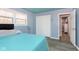Bedroom with teal bedding and access to another room at 1535 N Glen Arm Rd, Indianapolis, IN 46214