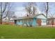 Side view of teal ranch home with brick and white accents, and a two-car garage at 1535 N Glen Arm Rd, Indianapolis, IN 46214