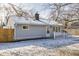 Rear view of charming gray house with white fence and snowy yard at 1811 E 75Th Pl, Indianapolis, IN 46240