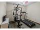 Compact home gym with a treadmill, weight machine, and TV at 10757 Kelly Ct, Indianapolis, IN 46231