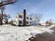 Rear view of the house showing a snow covered yard and detached garage at 1922 E 5Th St, Anderson, IN 46012