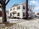 White two-story house with brick chimney, partially snow-covered yard at 1922 E 5Th St, Anderson, IN 46012