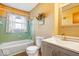 Updated bathroom with a teal tub, gray vanity, and modern fixtures at 807 Alden Dr, Fortville, IN 46040