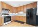 Light oak cabinets, black appliances, and mosaic backsplash at 807 Alden Dr, Fortville, IN 46040