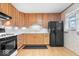 Light oak cabinets, black appliances, and mosaic backsplash at 807 Alden Dr, Fortville, IN 46040