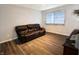 Living room with brown leather couch and wood-look flooring at 8435 Buckingham Dr, Columbus, IN 47201