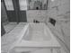 Soaking tub in a modern bathroom with marble tile at 1141 Temperance Ave, Indianapolis, IN 46203