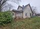 Two-story house needing renovation, with overgrown yard at 1207 W 35Th St, Indianapolis, IN 46208
