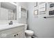 Small bathroom with light wood vanity, white toilet, and decorative wall art at 154 E Thompson Rd, Indianapolis, IN 46227