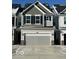 Two-story townhome with gray siding, black shutters, and a gray two-car garage at 18703 Moray St, Westfield, IN 46074