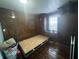 Small bedroom with wood paneled walls and hardwood floors at 323 E Franklin St, Shelbyville, IN 46176