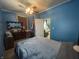 Blue bedroom with double bed, dresser, and access to another room at 323 E Franklin St, Shelbyville, IN 46176