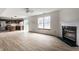 Spacious living room with wood-look flooring, fireplace, and adjacent kitchen at 6771 Lexington Cir, Zionsville, IN 46077