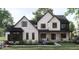 Two-story home with stone and dark trim, featuring a large front porch and landscaping at 8053 Easton Ln, Zionsville, IN 46077