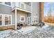 Small patio with wicker chairs, snowy ground and access to the home at 1216 Shadow Ridge Rd, Carmel, IN 46280