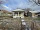 One-story home with a small front porch and a fenced yard dusted with snow at 1827 Mansfield St, Indianapolis, IN 46202