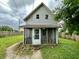 Rear view of house with porch and overgrown yard at 19 N Ritter Ave, Indianapolis, IN 46219