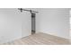Bedroom with sliding barn door closet and wood-look flooring at 2709 Station St, Indianapolis, IN 46218
