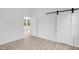 Bedroom featuring wood-look flooring, white walls, and barn door at 2709 Station St, Indianapolis, IN 46218