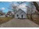 View of the back exterior of the home and gravel driveway from the yard at 2709 Station St, Indianapolis, IN 46218