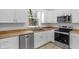 Modern kitchen with white cabinets, wood countertops, stainless steel appliances, and ample natural light at 2709 Station St, Indianapolis, IN 46218