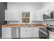 Modern kitchen featuring white cabinets, butcher block counters, and stainless steel appliances at 2709 Station St, Indianapolis, IN 46218