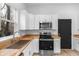 Updated kitchen with white shaker cabinets, stainless steel appliances, and butcher block countertops at 2709 Station St, Indianapolis, IN 46218