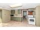 Small kitchen with green cabinets, white appliances, and laminate floor at 4925 W Raymond St, Indianapolis, IN 46241