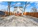 Fenced backyard with a wooden deck, light dusting of snow, and trees at 593 Walnut St, Noblesville, IN 46060