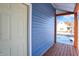 Wooden front porch with a white door against blue siding and a view of the street at 593 Walnut St, Noblesville, IN 46060