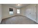 Empty bedroom with neutral carpet, windows, and a double closet door at 6110 Prairie Stream Way, Columbus, IN 47203