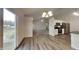 Open-concept kitchen and dining area with sliding glass doors, modern appliances, and wood-look flooring at 6110 Prairie Stream Way, Columbus, IN 47203